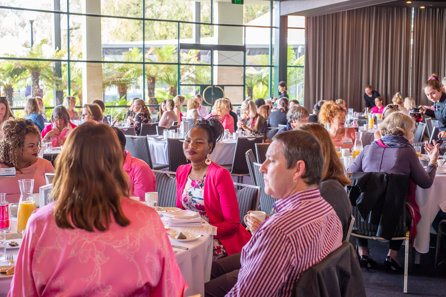 Attendees sitting and talking at Pink Ribbon Breakfast