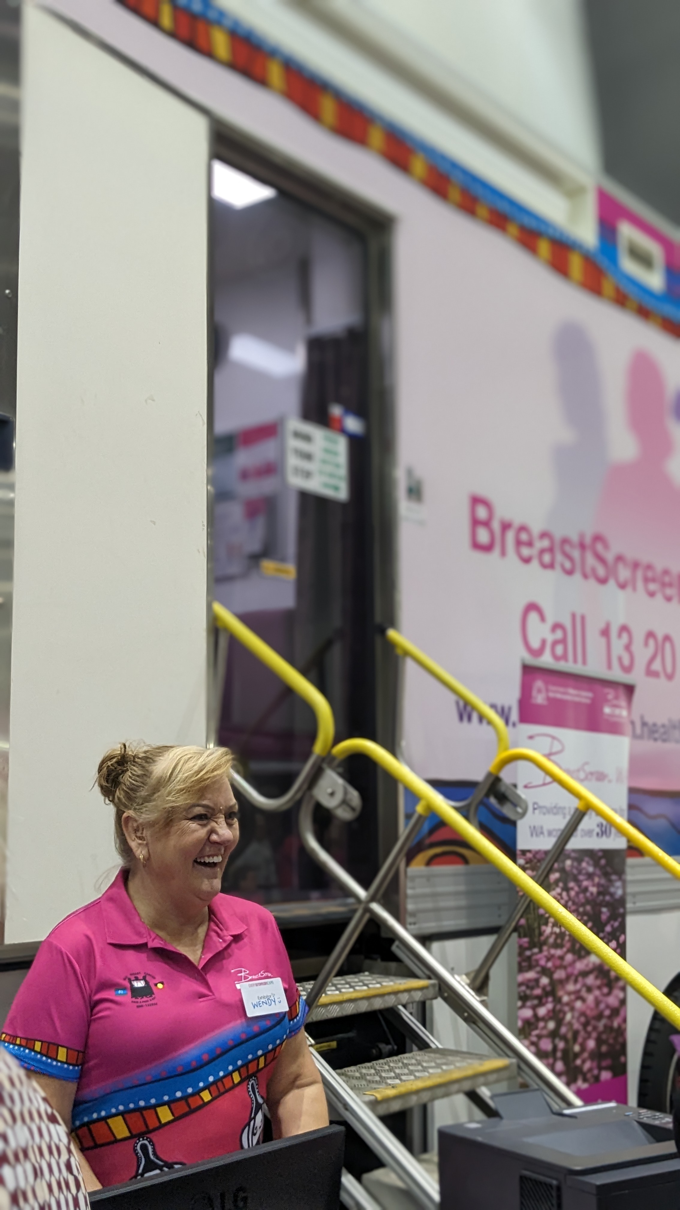 BreastScreen WA staff member smiling at client in front of screening truck