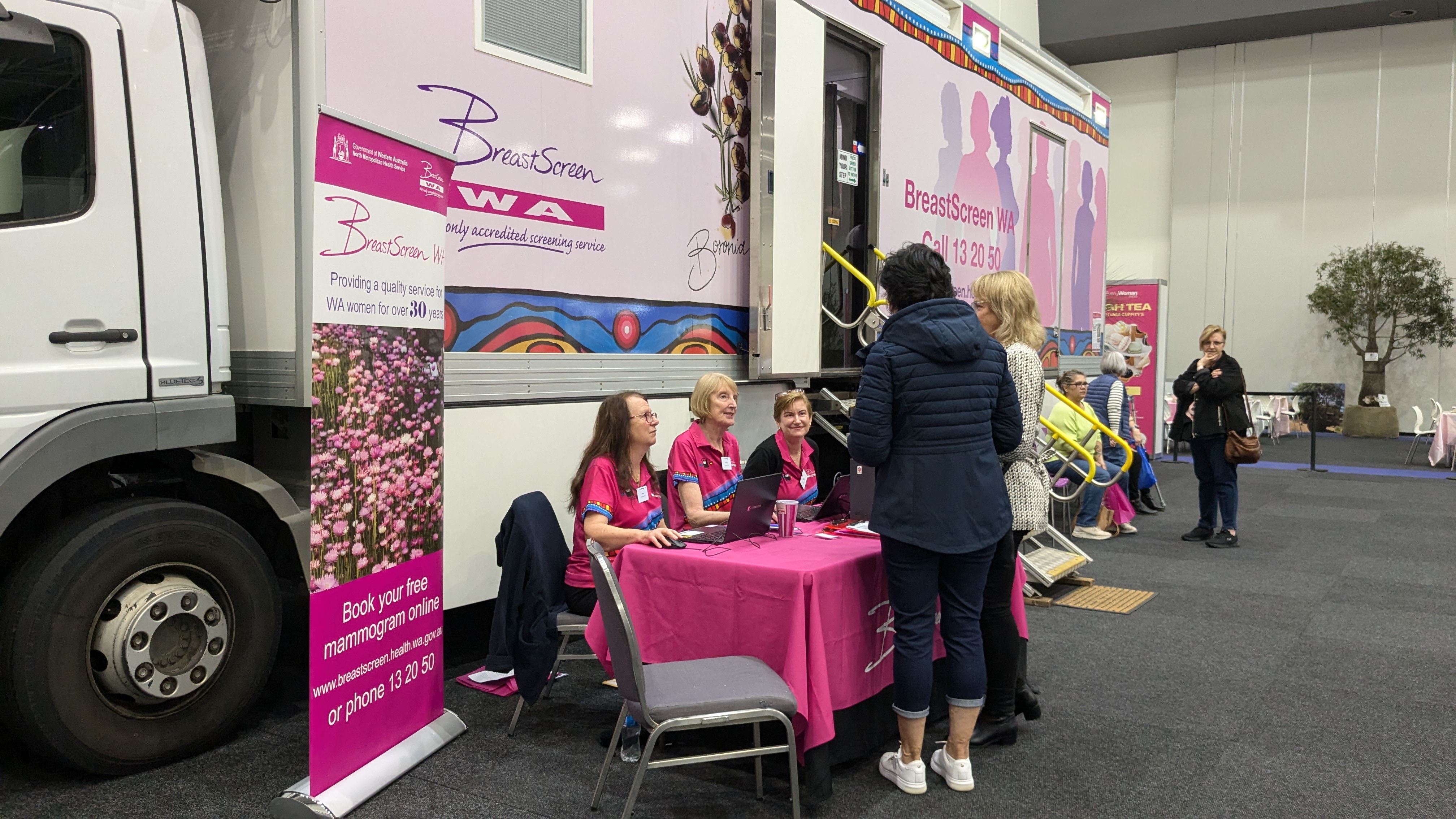 Woman talking to staff at front desk at EveryWoman Expo