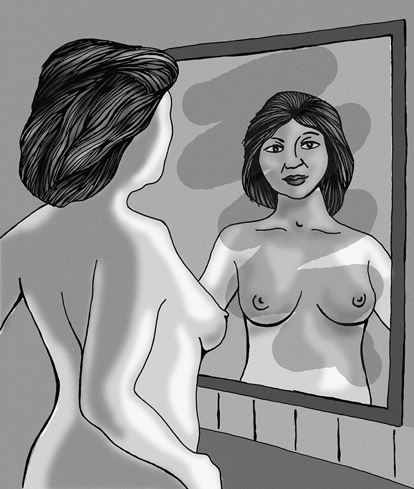 Woman checking her breasts in the mirror