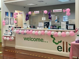 Reception desk decorated with pink balloons