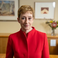 Headshot of Professor Clare Pollock wearing a red coat